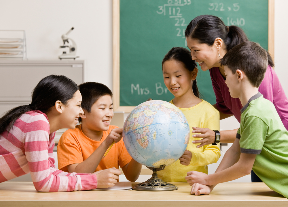 school children and teacher around the globe on a table