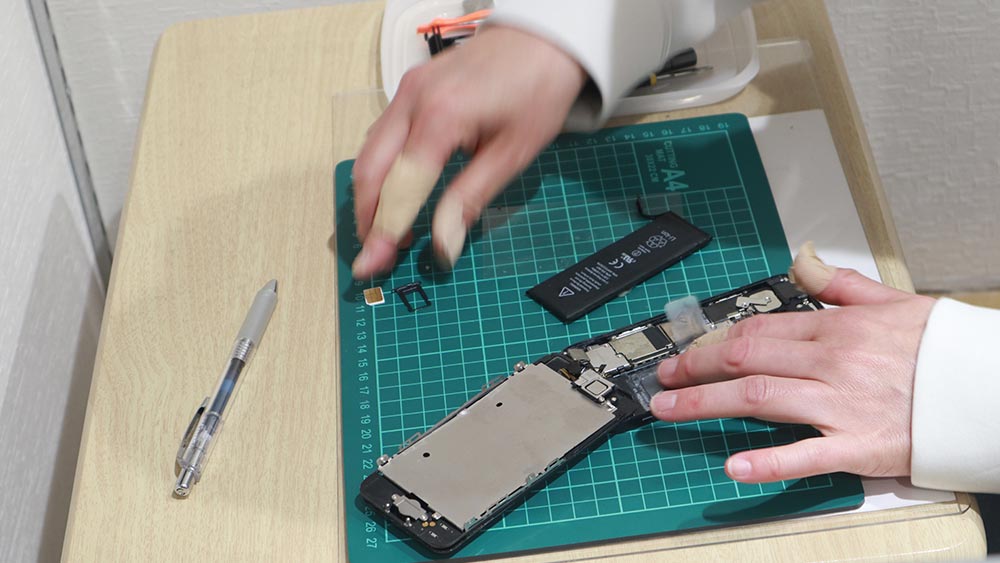 Staff removing battery from the smartphone.
