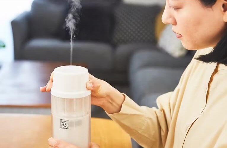 a woman sterilizing baby bottle using “Loipos Bottle Warmer”