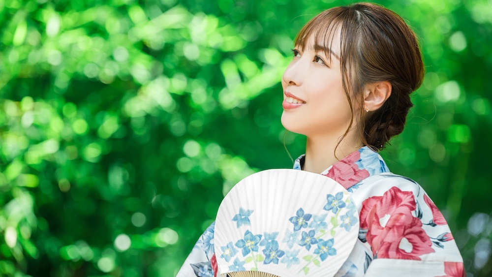 A woman holding Uchiwa fan